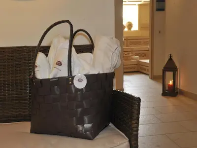 a basket filled with towels sitting on a couch at Hotel Dorfer Alpine&Charming in Selva di Val Gardena