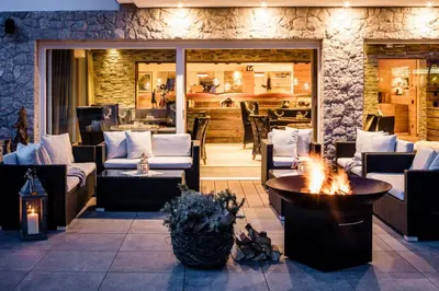 a patio with couches and a fire pit at Hotel Dorfer Alpine&Charming in Selva di Val Gardena