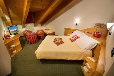a room with two beds and a television in it at Hotel Cristallo in Passo San Pellegrino