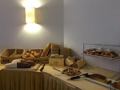 a table topped with baskets of bread and pastries at Hotel Cristallo in Passo San Pellegrino