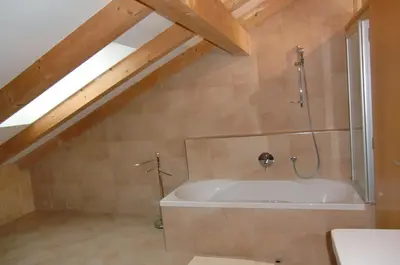 a bathroom with a bath tub in a attic at Neuprantl Apartments in Lana