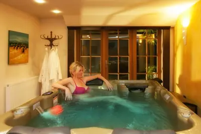 a woman sitting in a hot tub in a room at Neuprantl Apartments in Lana