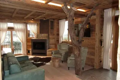 a living room with a tree in the middle at Neuprantl Apartments in Lana