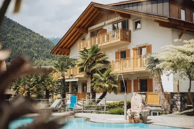 a resort with a swimming pool and a building at Residence Hoferhof in Lana