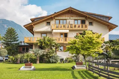 a house in the mountains with a yard at Residence Hoferhof in Lana