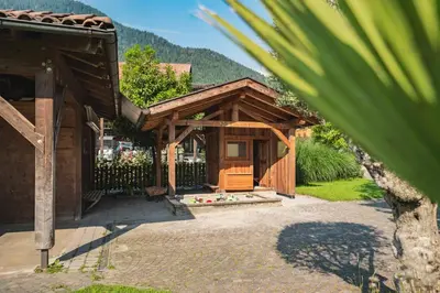 a wooden pavilion with a chair on a patio at Residence Hoferhof in Lana