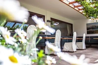 a group of chairs sitting on a porch with a mirror at Das Bergland - Vital & Activity in San Leonardo in Passiria