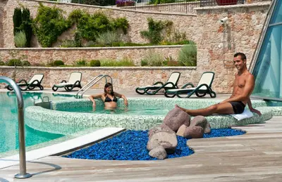 a man and woman in a swimming pool with teddy bears at La Quiete Resort in Romeno