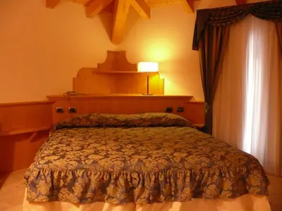 a bedroom with a bed with a lamp and a window at La Quiete Resort in Romeno