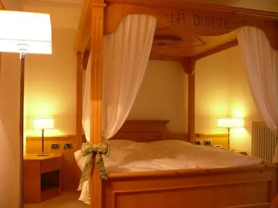 a bedroom with a canopy bed and two lamps at La Quiete Resort in Romeno