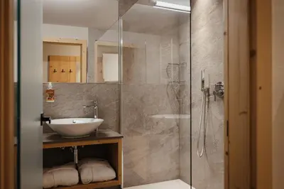 a bathroom with a sink and a glass shower at Hotel La Montanara Predazzo in Predazzo