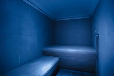 a blue room with a bench in the corner at Hotel La Montanara Predazzo in Predazzo