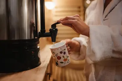 a person is holding a coffee cup with affe at Hotel La Montanara Predazzo in Predazzo