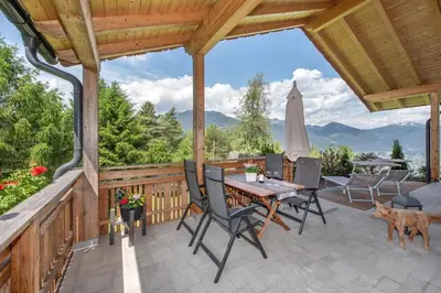 a patio with a table and chairs and a umbrella at Apartmenthaus Fuchsmaurer in Bressanone