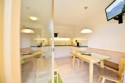 a kitchen and dining room with a table and a television at Apartmenthaus Fuchsmaurer in Bressanone