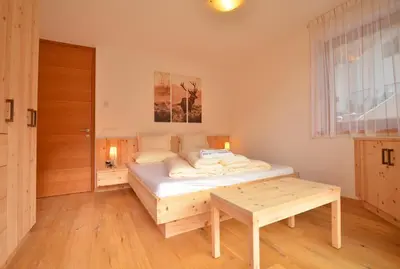 a bedroom with a bed and a table in it at Apartmenthaus Fuchsmaurer in Bressanone
