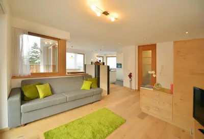 a living room with a couch and a television at Apartmenthaus Fuchsmaurer in Bressanone