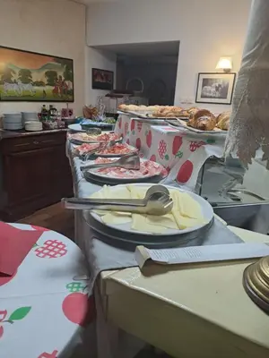 a table with plates and utensils on top at B&B Hotel Dolomiti in Bolzano