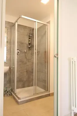a shower with a glass door in a bathroom at Apartment Haus Lang in Lagundo