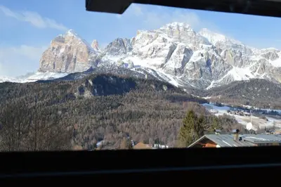 a view of a snowy mountain range from a window at I mughi - Cortina in Cortina dʼAmpezzo