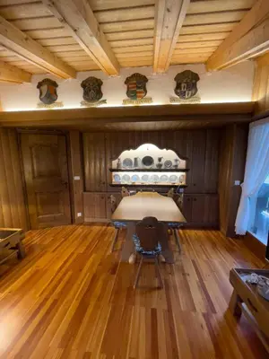 a living room with a table and wooden floors at I mughi - Cortina in Cortina dʼAmpezzo