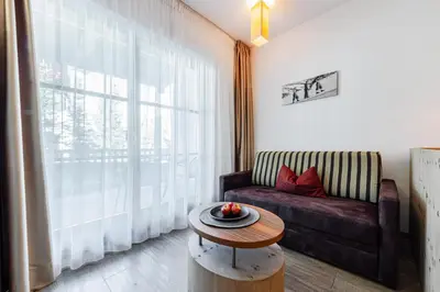 a living room with a couch and a table at Hotel Stoeres - Active wellbeing in San Cassiano
