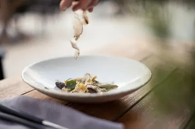 a person eating a plate of food on a table at Chalet PURMONTES in San Lorenzo di Sebato
