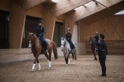 a group of people riding horses in a building at Chalet PURMONTES in San Lorenzo di Sebato