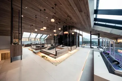a lobby of a building with benches and tables at Chalet PURMONTES in San Lorenzo di Sebato