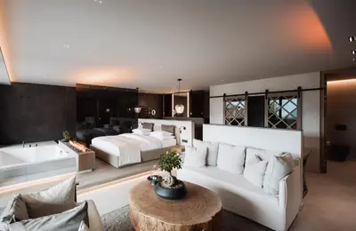 a living room with a white couch and a bed at Chalet PURMONTES in San Lorenzo di Sebato