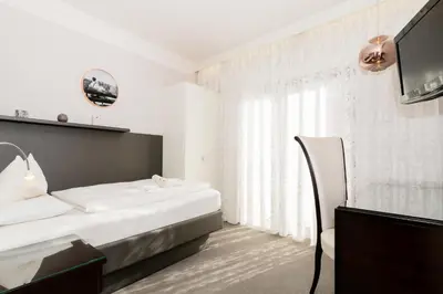 a hotel room with a bed and a television at Hotel Villa Groff in Ora/Auer