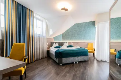 a bedroom with a bed and a table and chairs at Hotel Villa Groff in Ora/Auer