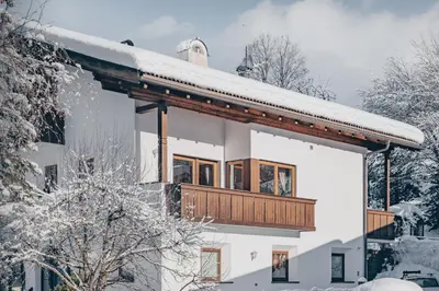 a house with a balcony in the snow at Villa Moroder in Ortisei