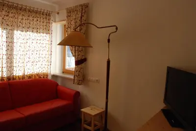 a living room with a red couch and a lamp at Villa Moroder in Ortisei