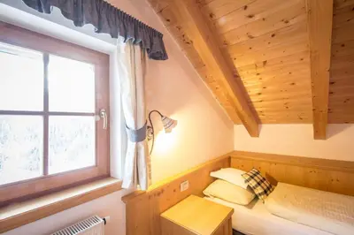a bedroom with a bed and a window at Dolomites Apartments Ciasa Vally in San Cassiano