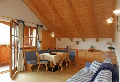 a living room with a table and a kitchen at Dolomites Apartments Ciasa Vally in San Cassiano