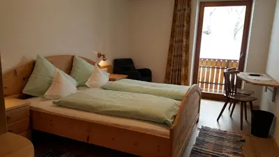 a bedroom with a bed and a chair and a window at Hotel Pension Moarhof in Vallarga