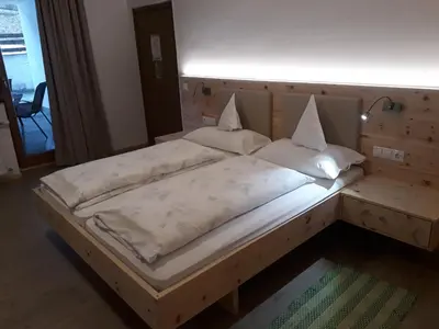 a large bed with a wooden headboard in a room at Hotel Pension Moarhof in Vallarga