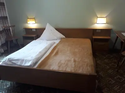 a large bed in a room with two lights at Hotel Pension Moarhof in Vallarga