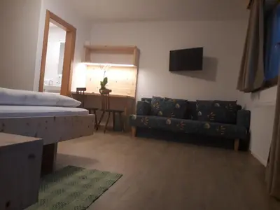 a living room with a couch and a bed at Hotel Pension Moarhof in Vallarga