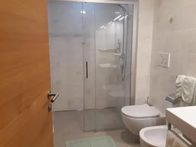 a bathroom with a shower with a toilet and a sink at Hotel Pension Moarhof in Vallarga