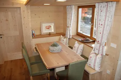 a dining room with a wooden table and chairs at Lehrnerhof Lüsen in Luson