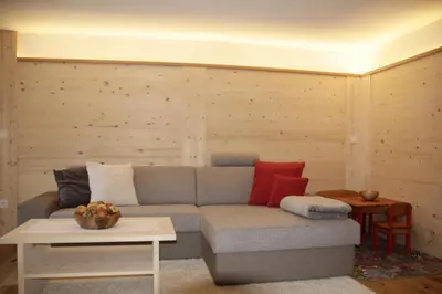 a living room with a gray couch with colorful pillows at Lehrnerhof Lüsen in Luson