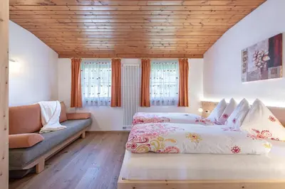 a kitchen and a living room with a table and chairs at Harrerhof in Perca