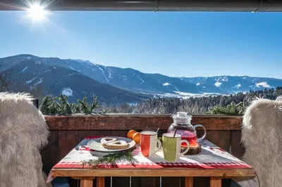 a table with food and drinks on a balcony with mountains at Harrerhof in Perca
