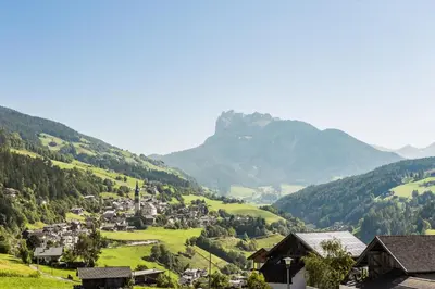 a village in a valley with a mountain in the background at Appartements Sonneck in Funes