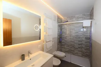 a bathroom with a sink and a toilet and a mirror at Residence Albierch in Ortisei