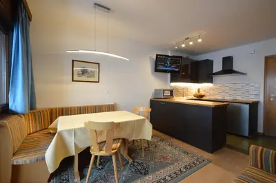 a dining room and kitchen with a table and chairs at Residence Albierch in Ortisei