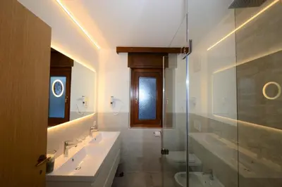 a bathroom with two sinks and a glass shower at Residence Albierch in Ortisei