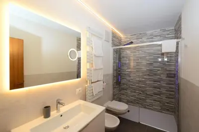 a bathroom with a sink and a toilet and a mirror at Residence Albierch in Ortisei